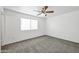 This cozy bedroom features neutral carpet, a ceiling fan, and a large window for plenty of natural light at 4144 N 109Th Ave, Phoenix, AZ 85037