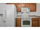 The kitchen features white appliances, wood cabinets, and a view into the dining room at 4144 N 109Th Ave, Phoenix, AZ 85037