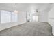 Open-concept living room with neutral carpet, a fireplace, a ceiling fan, and sliding glass doors at 4144 N 109Th Ave, Phoenix, AZ 85037