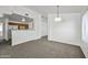 Spacious living room with neutral carpet, view into kitchen, and a ceiling light at 4144 N 109Th Ave, Phoenix, AZ 85037