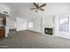 Spacious open-concept living room featuring a fireplace, view into kitchen, and a ceiling fan at 4144 N 109Th Ave, Phoenix, AZ 85037
