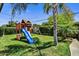 Backyard features a wooden playset with slide, swing, and climbing area, all surrounded by lush green grass at 4243 E Avalon Dr, Phoenix, AZ 85018
