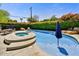 Resort-style pool area with a spa, dining and lounge seating, lush landscaping, and beautiful blue water at 4243 E Avalon Dr, Phoenix, AZ 85018