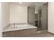 Modern bathroom featuring a soaking tub with marble surround and a glass-enclosed shower at 4803 N Woodmere Fairway -- # 1002, Scottsdale, AZ 85251