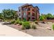 Condo building surrounded by xeriscaped landscape featuring flowering bushes at 4803 N Woodmere Fairway -- # 1002, Scottsdale, AZ 85251