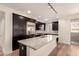 Open kitchen with an island, granite countertops, stainless steel appliances, and hardwood floors at 4803 N Woodmere Fairway -- # 1002, Scottsdale, AZ 85251