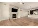 Spacious living area with a fireplace, hardwood floors, and an open layout leading to the kitchen at 4803 N Woodmere Fairway -- # 1002, Scottsdale, AZ 85251