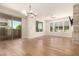 Sunlit living room with sliding glass doors, hardwood floors, and modern lighting fixture at 4803 N Woodmere Fairway -- # 1002, Scottsdale, AZ 85251