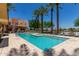 Community pool featuring palm trees, lounge seating and beautiful Arizona blue skies at 4803 N Woodmere Fairway -- # 1002, Scottsdale, AZ 85251
