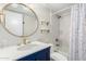 Bathroom with blue vanity, gold fixtures, and a modern round mirror at 4845 W Sweetwater Ave, Glendale, AZ 85304
