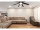 A living room featuring hardwood floors, a sectional, and a large fan at 4845 W Sweetwater Ave, Glendale, AZ 85304