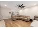 A living room featuring hardwood floors, a sectional, and a large fan at 4845 W Sweetwater Ave, Glendale, AZ 85304