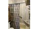 Shower with a patterned curtain and shelving for toiletries, providing convenience at 5735 N 32Nd Dr, Phoenix, AZ 85017