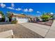 This single story home boasts a two-car garage, mature landscaping, and a quaint brick walkway at 5803 W John Cabot Rd, Glendale, AZ 85308