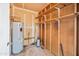 Utility room in the garage area with a water heater and some shelving and exposed studs at 5803 W John Cabot Rd, Glendale, AZ 85308
