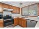 The kitchen offers ample counter space with modern appliances and wood cabinets with a backyard view at 5803 W John Cabot Rd, Glendale, AZ 85308