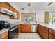 Traditional style kitchen features stainless steel appliances, tile flooring and a window overlooking the backyard at 5803 W John Cabot Rd, Glendale, AZ 85308