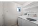 Functional laundry room with appliances, shelving, and a window, offering convenience and storage solutions at 5803 W John Cabot Rd, Glendale, AZ 85308