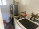 A utility room with a water heater, laundry sink, and a washing machine at 61 W 11Th Dr, Mesa, AZ 85210