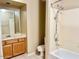 Bathroom featuring wood cabinets, a toilet, and shower/tub combo at 6376 W Adobe Dr, Glendale, AZ 85308