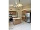 Well-lit kitchen features wood cabinets, island, tile floors, and stainless steel refrigerator at 6376 W Adobe Dr, Glendale, AZ 85308