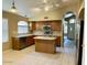 Well-lit kitchen features wood cabinets, island, tile floors, and stainless steel microwave at 6376 W Adobe Dr, Glendale, AZ 85308