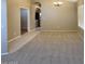 View of a neutral living room with large cased opening into another room, plus chandelier lighting at 6376 W Adobe Dr, Glendale, AZ 85308