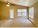 Neutral living room with a ceiling fan and large windows bringing in natural light at 6376 W Adobe Dr, Glendale, AZ 85308