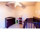 Bedroom with carpet, ceiling fan, changing table, and crib at 6415 W Escuda Rd, Glendale, AZ 85308