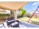 Relaxing covered patio area with comfortable seating, overlooking the lush backyard, perfect for outdoor living at 6415 W Escuda Rd, Glendale, AZ 85308