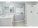 Bright bathroom features double sinks, modern hardware, a walk-in shower, and a bright window at 10022 W Mountain View Rd, Sun City, AZ 85351