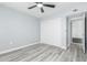 Bedroom with modern laminate flooring, bright white closet doors, and a ceiling fan at 10022 W Mountain View Rd, Sun City, AZ 85351