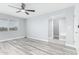Light and airy bedroom features modern laminate flooring, light gray walls, and a bright window at 10022 W Mountain View Rd, Sun City, AZ 85351