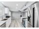 Modern kitchen featuring stainless steel appliances, white cabinetry, and contemporary finishes at 10022 W Mountain View Rd, Sun City, AZ 85351