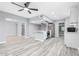 Bright living room features an open floor plan, modern fixtures, and stylish gray wood laminate flooring at 10022 W Mountain View Rd, Sun City, AZ 85351
