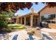 Beautiful backyard featuring a covered patio, putting green, hot tub, and lush desert landscaping at 11103 E Blue Sky Dr, Scottsdale, AZ 85262