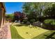 Backyard putting green surrounded by mature trees and desert landscaping at 11103 E Blue Sky Dr, Scottsdale, AZ 85262