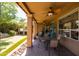 Spacious covered patio with ceiling fans, dining area, and view of backyard putting green and hot tub at 11103 E Blue Sky Dr, Scottsdale, AZ 85262