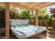 Inviting backyard hot tub with surrounding desert landscaping and pergola at 11103 E Blue Sky Dr, Scottsdale, AZ 85262