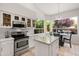 Bright kitchen with stainless steel appliances, white cabinets, and a granite island at 11103 E Blue Sky Dr, Scottsdale, AZ 85262
