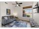 Inviting living room featuring a comfortable sofa, ceiling fan, and large windows overlooking the backyard at 11103 E Blue Sky Dr, Scottsdale, AZ 85262