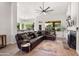 Spacious living room with a fireplace, modern decor, and large leather sectional sofa at 11103 E Blue Sky Dr, Scottsdale, AZ 85262