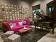 Vibrant living room featuring a plush pink sofa, baby grand piano, and stylish decor at 11320 E Winchcomb Dr, Scottsdale, AZ 85255