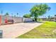 Large backyard area with a concrete pad, block fencing, and views of mature shade trees at 1208 E Tuckey Ln, Phoenix, AZ 85014