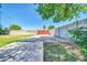 Spacious fenced yard area features a concrete pad, landscaping, and mature shade trees at 1208 E Tuckey Ln, Phoenix, AZ 85014