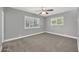 Well-lit bedroom with two windows, plush carpet, and neutral gray walls at 1208 E Tuckey Ln, Phoenix, AZ 85014