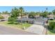 Home's exterior showcases mature landscaping, palm tree, and a water feature, and long driveway at 1208 E Tuckey Ln, Phoenix, AZ 85014