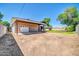 Detached garage and extra parking featuring gravel area adjacent to backyard with lush greenery and blue skies at 1208 E Tuckey Ln, Phoenix, AZ 85014