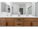 Bright bathroom featuring double sinks with wood cabinets and granite countertops at 12204 W Parkway Ln, Avondale, AZ 85323