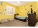 Bedroom with yellow walls, carpeted floor, a ceiling fan, and a bed with storage underneath at 12204 W Parkway Ln, Avondale, AZ 85323